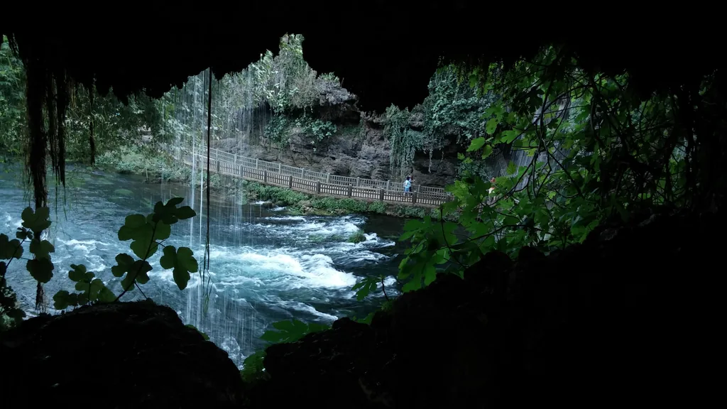 Looking out from inside the cave behind the Upper Düden waterfall, water falling as a curtain in front of the opening