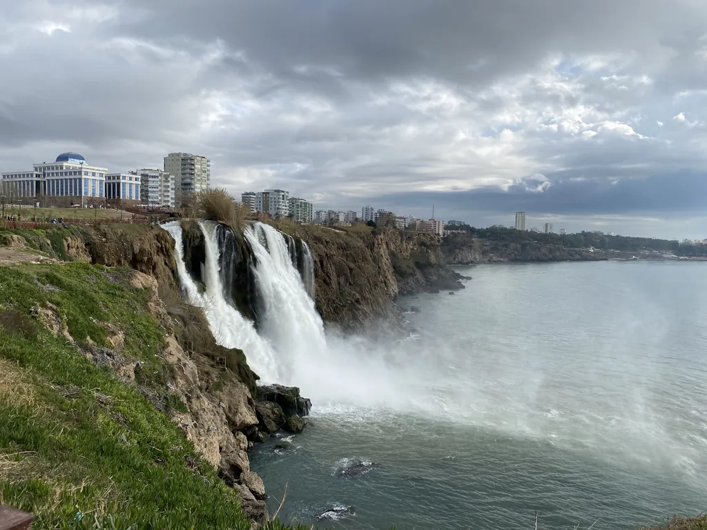 The Lower Düden waterfall dropping from the cliff into the Mediterranean, with Antalya behind